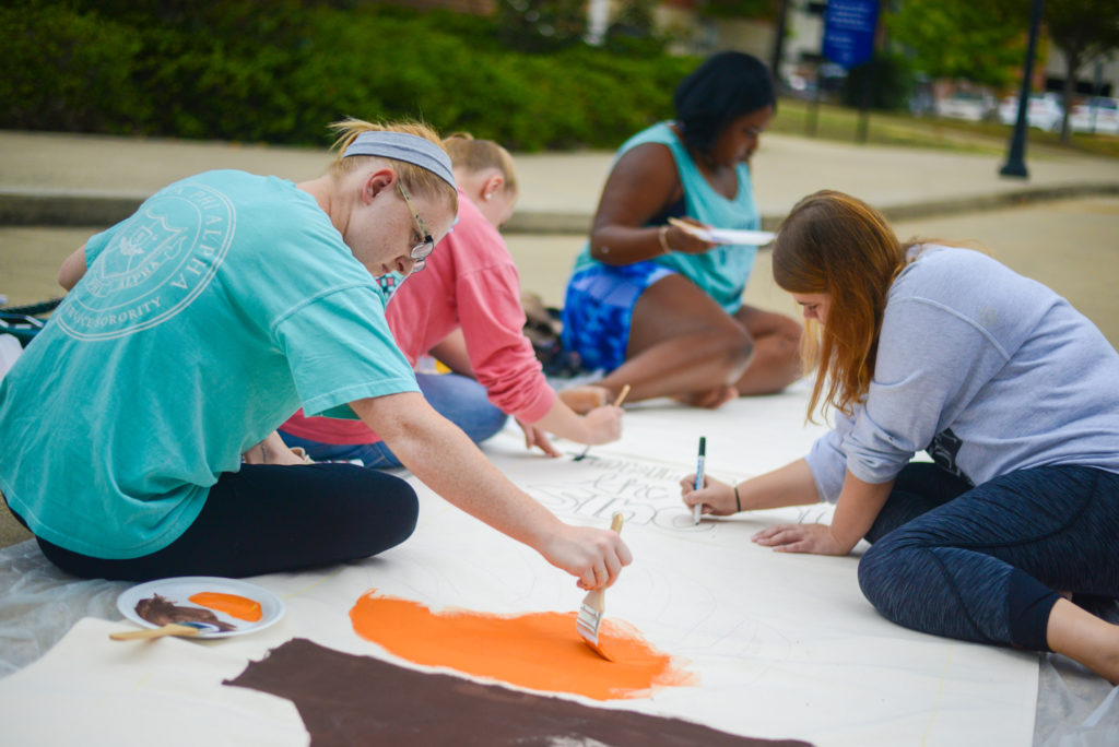 students paint banners outdoors on the UTC quad