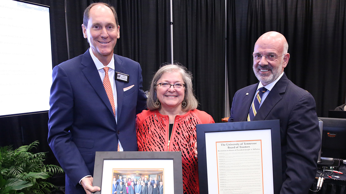 Board Chair John Compton presents Deb and Joe DiPietro with a framed portrait and framed resolution naming DiPietro president emeritus of the University of Tennessee