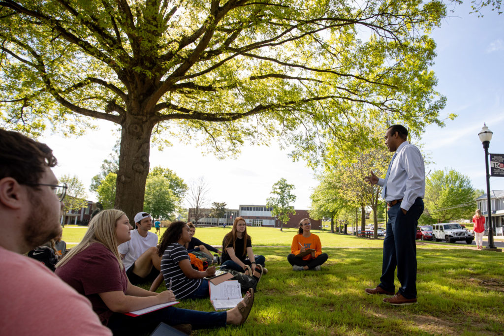 A professor talks to a group of students outdoors on the Pulaski campus
