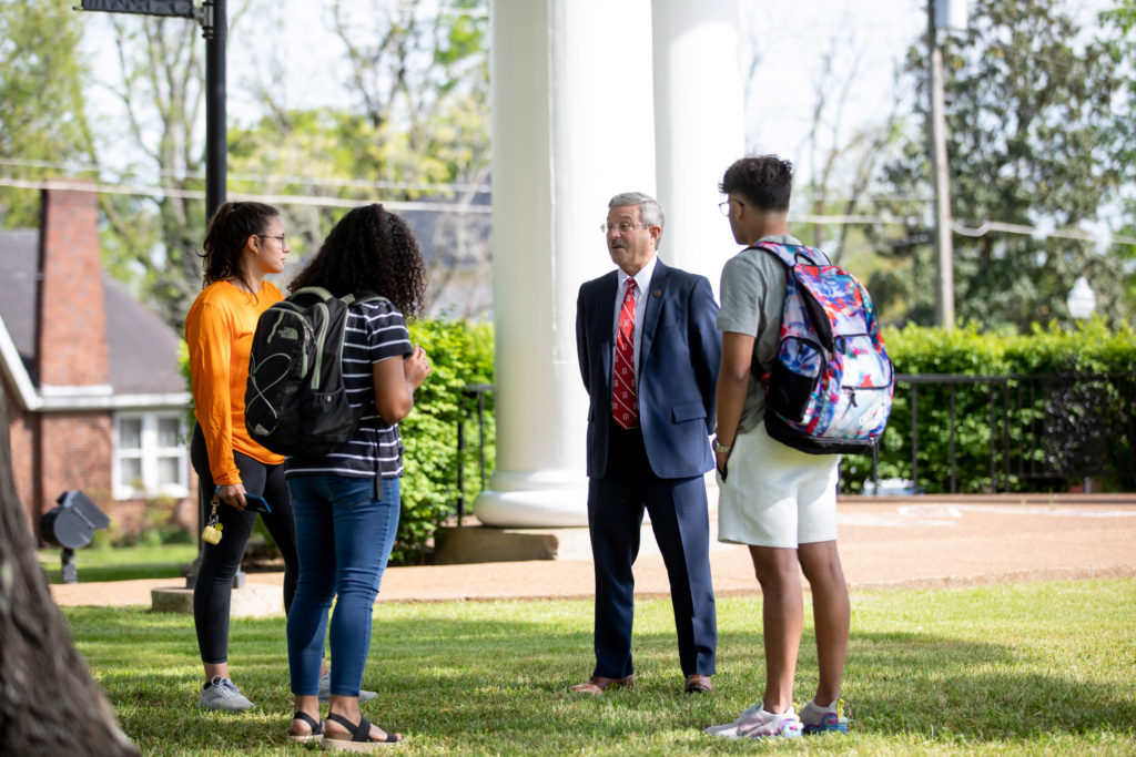 UT Southern chancellor Mark La Branche talks with a group of three students outdoors