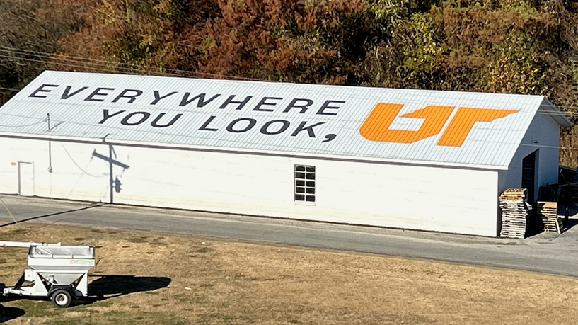 Gray and orange "Everywhere You Look, UT" mural on white barn roof in Jackson, Tennessee
