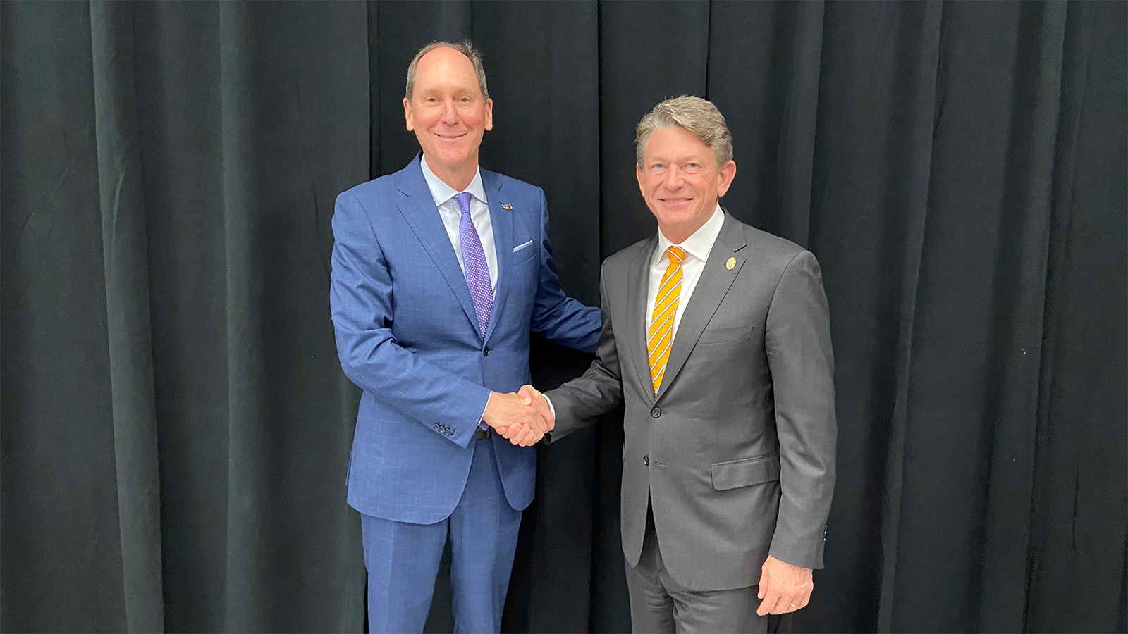 UT System President Randy Boyd shakes hands with UT Board of Trustees Chair John Compton.